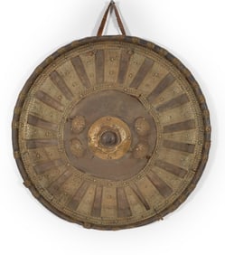 Hide shield, Ethiopia, early 20th Century. Repousse brass mounts with floral decoration. Diameter 19