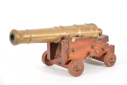 Late 19th century bronze signal cannon on wooden carriage with brass studded wheels. Adjustable