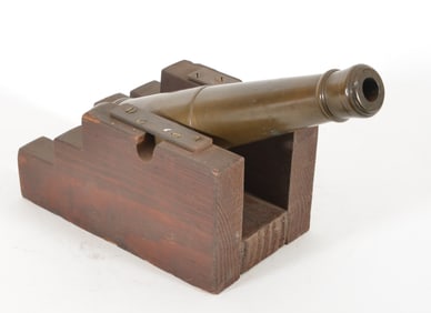 Late 19th century bronze signal cannon. Flat wooden carriage with metal mounts. Wear consistent with
