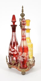 Early 20th century 3-decanter tantalus. Wooden stand with gilt bronze mounts. 3 flashed and cut