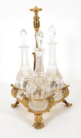 Early 20th century gilt bronze 3-decanter tantalus with cut glass bottles. Overall: 17.5in high,