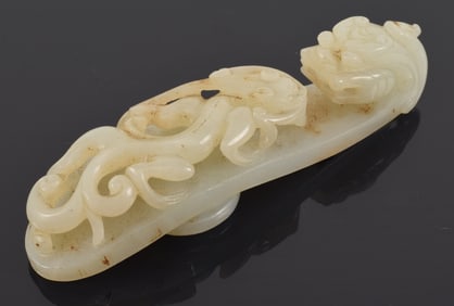 White jade garment hook. China. 19th century or earlier. Carved kylin decoration. 4.75in length.