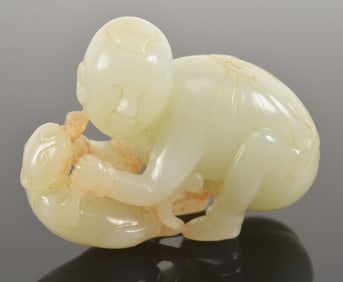Jade carving. China. 18th century. Small child playing with a kitten. Highly translucent white
