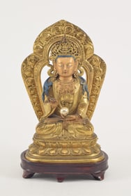 Gilt bronze image of a buddha. China. 18th century. Seated figure. Gilt halo on the back. Bronze: