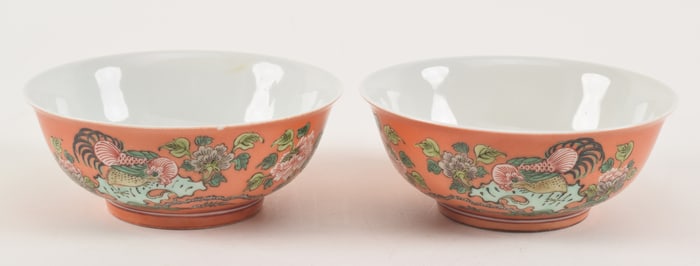 Pair of 19th/20th century coral ground Chinese porcelain bowls with rooster in landscape famille