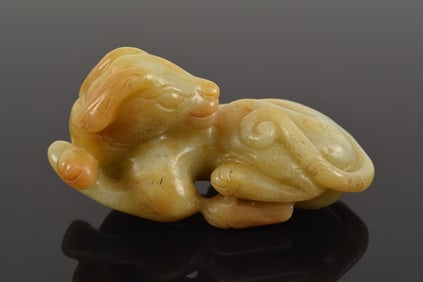 Jade carving. China. 17th century. Yellow stone. Carving of a resting dog. 3.125in.