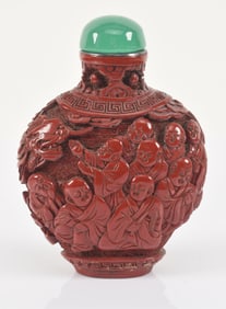 Cinnabar snuff bottle. China. 18th century. Surface carved with buddhist saints. Silver mouth rim.