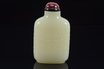 Jade snuff bottle. China. 18th century. Pure white stone carved with archaic tao tieh masks. 2.75in.