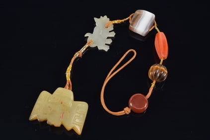 Jade pendant. China. Probably Shang period. In the form of a bat. Traces of ochre remaining. Mounted