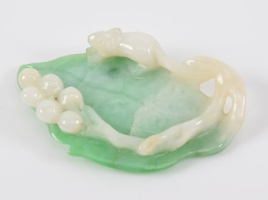 Jadeite carving. China. 19th century. Carved in a squirrel and grape motif. 1.25in length.