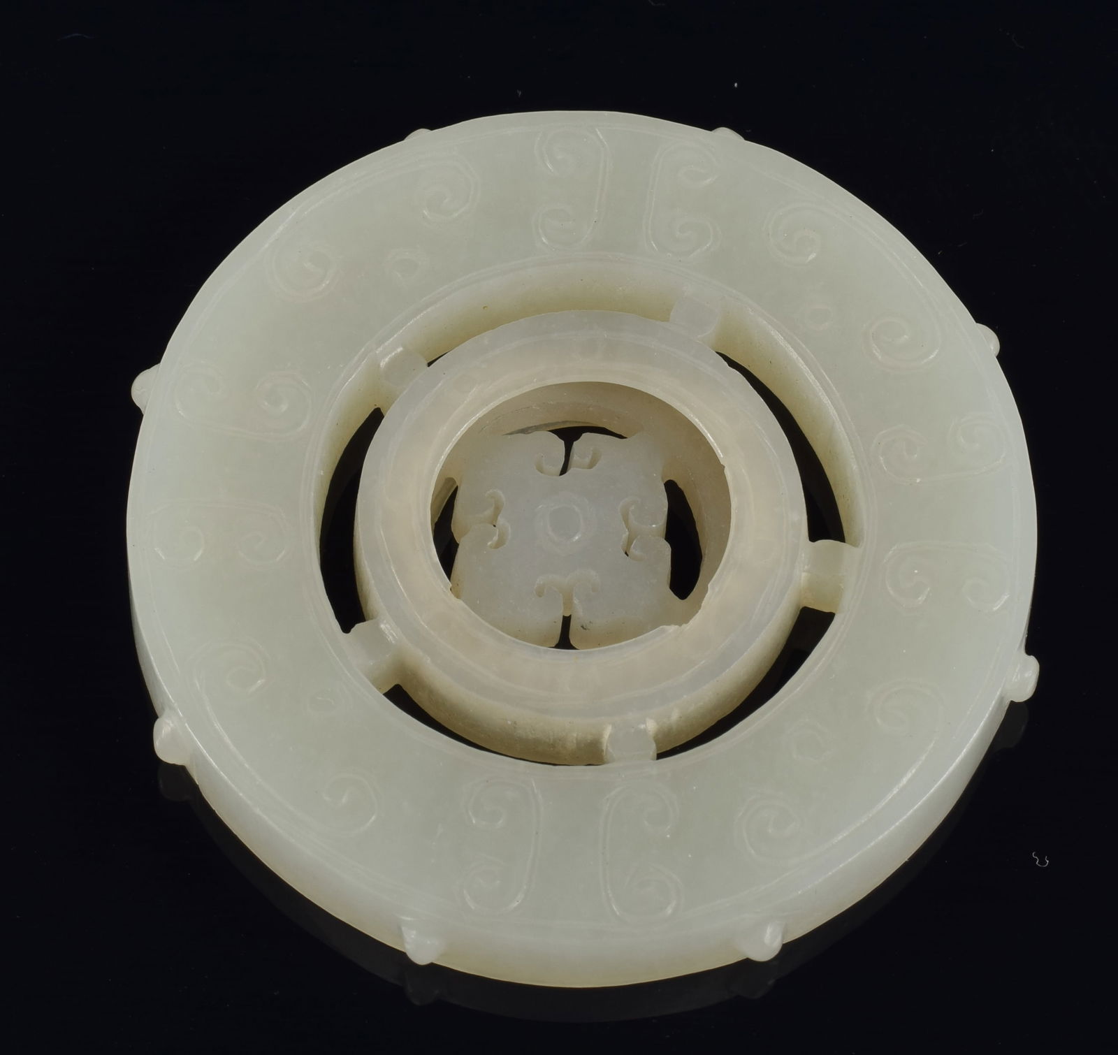 Jade disc pendant. China. 19th/20th century. Pierced and carved comma decoration. Central disc (1 of 3)