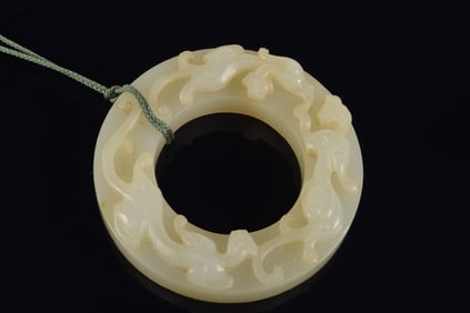 Jade ritual disc. China. 18th century. Surface carved with chih lung and comma marks. 2.5in.
