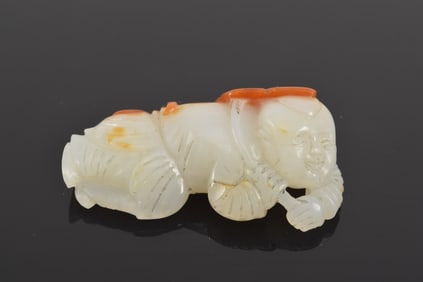 Jade carving of a small child. China. 18th century. Pure white stone with a bright red marking. 2in.