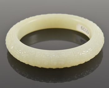 Jade bracelet. China. 19th century or earlier. Overall carved with commas. 3.5in diameter.