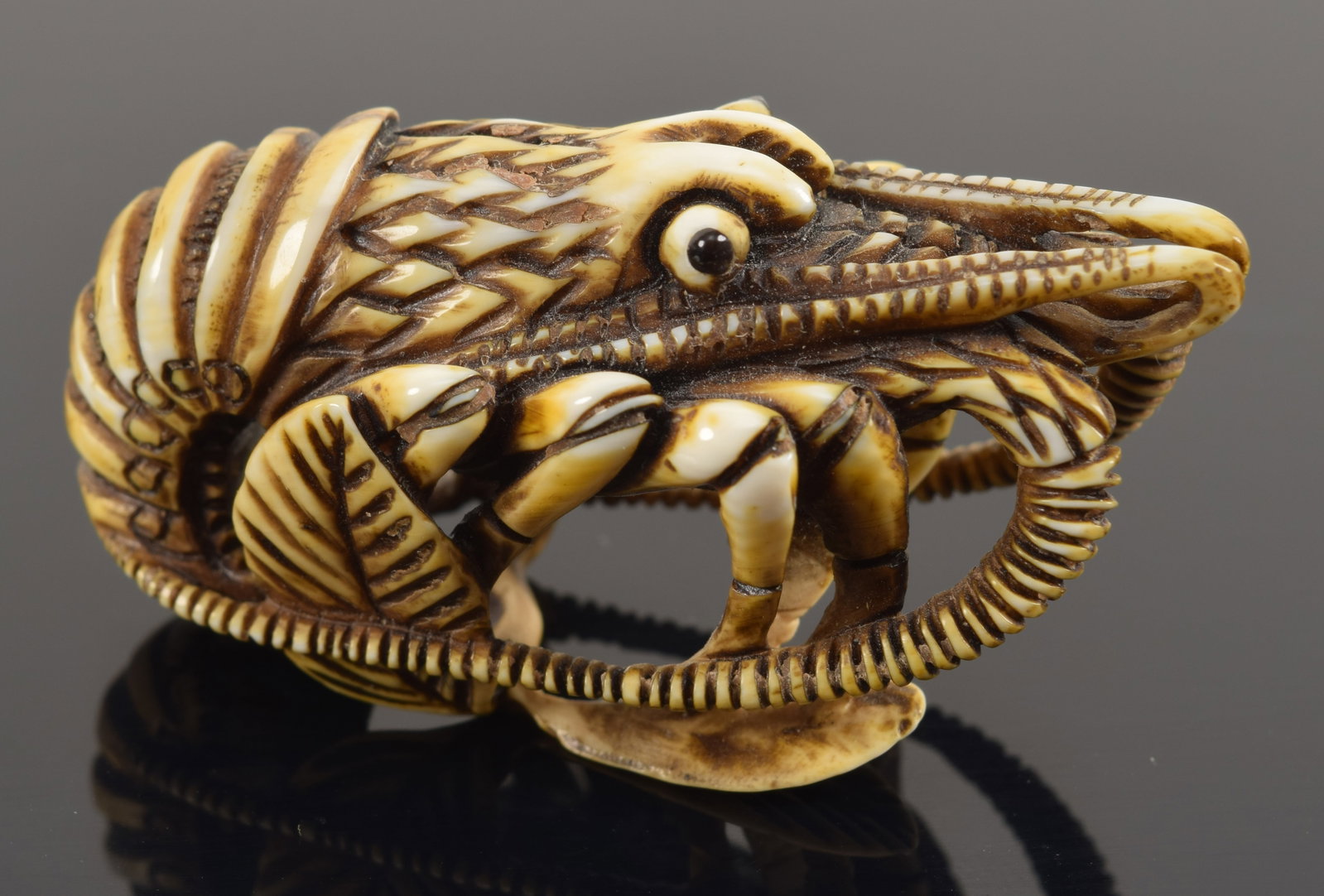Carved toggle. Japan. 18th/19th century. Netsuke study of a crayfish. signed Tomotada. 2in length.: Carved toggle. Japan. 18th/19th century. Netsuke study of a crayfish. signed Tomotada. 2in length.Buyer's notice: This item can only be purchased and picked up from our gallery in Massachusetts. We wi