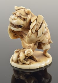 Netsuke. Japan. 19th century. Study of 2 children playing with a shishi mask. Signed. 1.5in. In a
