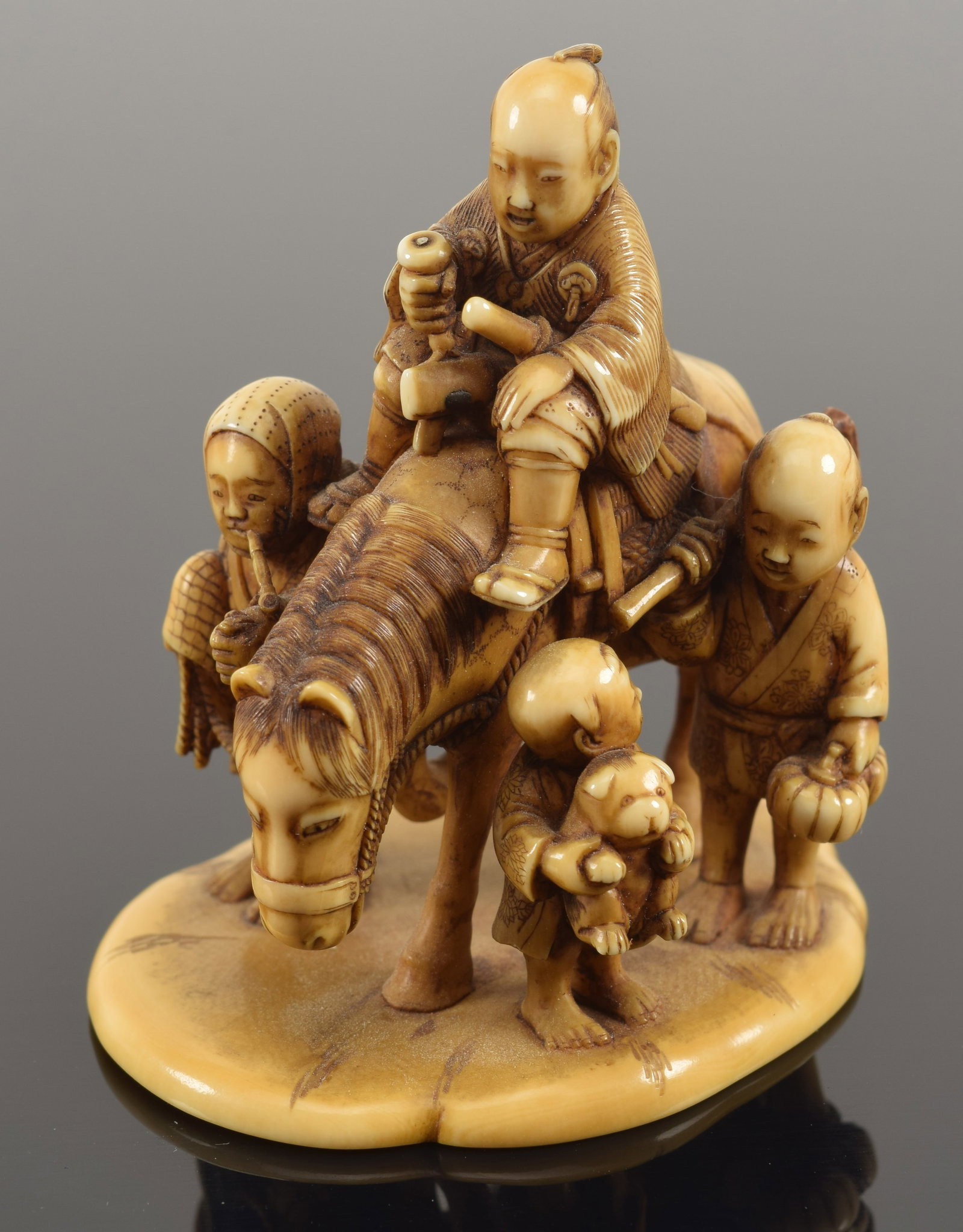 Carved toggle. Japan. 19th century. Netsuke study of a rider with attendants. Signed. 2 x 2in.: Carved toggle. Japan. 19th century. Netsuke study of a rider with attendants. Signed. 2 x 2in.Buyer's notice: This item can only be purchased and picked up from our gallery in Massachusetts. We will n