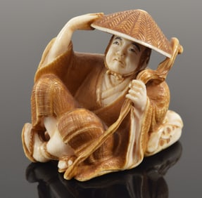 Carved toggle. Japan. 19th century. Netsuke with scene of a traveler. Signed. 1.25in.