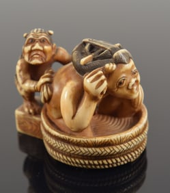 Carved toggle. Japan. 19th century. Netsuke of an Oni bathing a woman. Signed Hidemasa. 1.5in