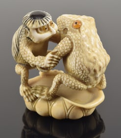 Carved toggle. Japan. 19th century. Netsuke of a frog and kappa wrestling of a lotus leaf. 2in.