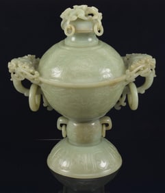 Jade covered jar. China. Early 20th century. Highly translucent celadon green jade. Ornate lion mask