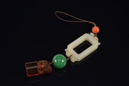 Pendant. China. To include: A carved coral bead, a jadeite bead, an amber seal and 18th century