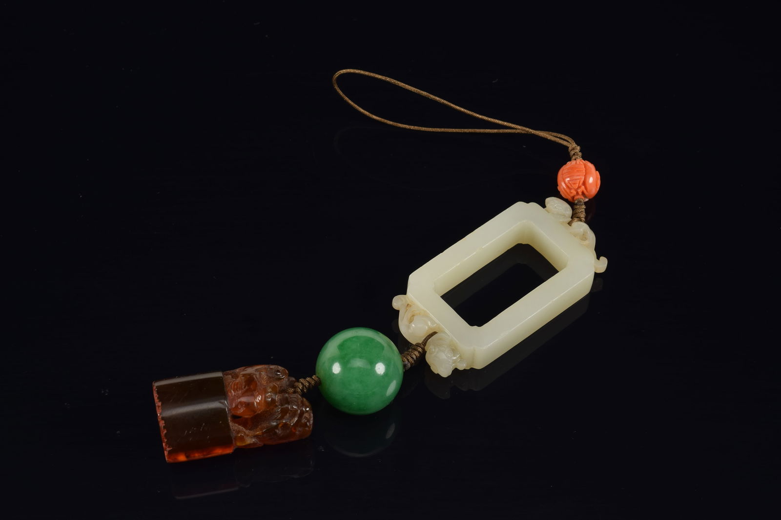Pendant. China. To include: A carved coral bead, a jadeite bead, an amber seal and 18th century (1 of 6)