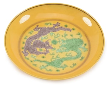 Porcelain saucer dish. China. Early 20th century. Yellow ground with san tsai dragons and grapes.
