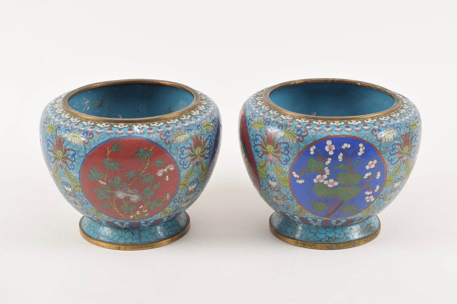 Pair of cloisonne bowls. China. Late 19th/early 20th century. Floral scenes on a stylized lotus: Pair of cloisonne bowls. China. Late 19th/early 20th century. Floral scenes on a stylized lotus scrolled turquoise ground. 10 x 8.5in.