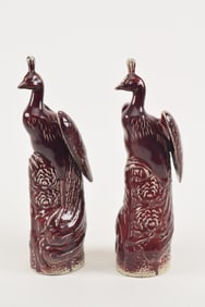 Pair of oxblood glazed phoenixes. China. 19th century. Height 15in. One with old repair to crest.
