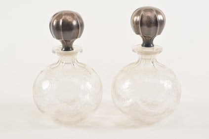 Pair of Gorham sterling silver topped etched glass decanters. Round form with etched floral garland