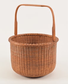 Large Mid-20th Century Nantucket open basket with squared swing handle. Turned base with concentric