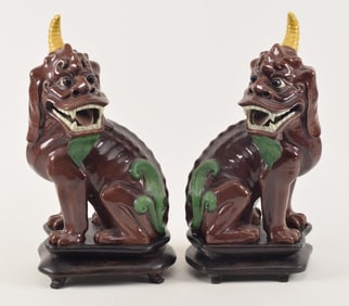 Pair of single horned kylin. China. Early 20th century. San Tsai glazed chih lung. Fitted stands.