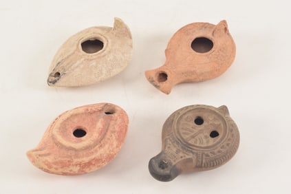 4 ancient pottery lamps. Decorated surfaces. Each about 4in.