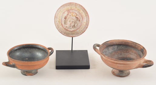3 ancient pottery works. To include: 2 kylix and a cover with a medusa boss. Largest 7in.