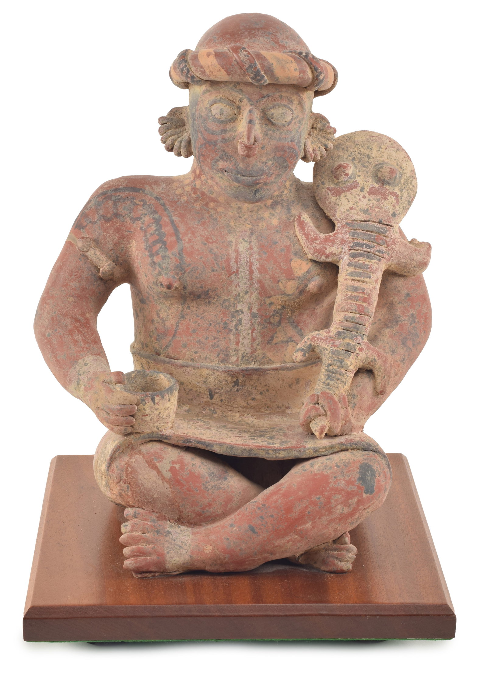 Pre-Columbian pottery seated figure holding a lizard. Black decoration. Mounted to wooden base. (1 of 7)