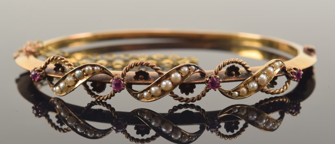 Antique 15K gold ruby and pearl mounted bangle bracelet. Marked 15CT. 2.5in wide. 6.8 grams.