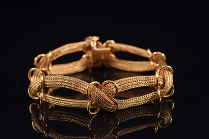 14K gold woven band style bracelet. Multi strand woven design with quatrefoil elements. Clasp marked