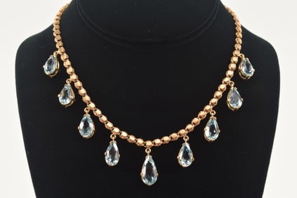 14K gold aquamarine mounted necklace. Largest pear cut stone at center 16.5 x 8mm. Other 8 stones