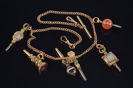 14K and 10K gold watch chain together with 6 ornate pocket watch keys set with carnelian, agate, syn