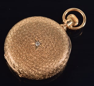14K gold Waltham hunter case pocket watch. Case engraved with intricate allover spiral motif. Back