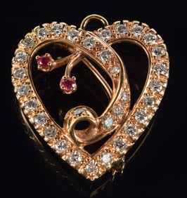 14K gold diamond and ruby mounted heart form pin/pendant. Scrolling heart contour design set with 32