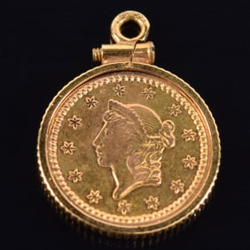 1853 US $1 dollar gold liberty head coin. 14K gold pendant setting. 14.5 x 19.6mm overall. 2 grams.