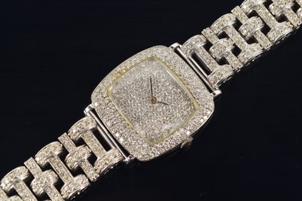 18K white gold diamond encrusted wristwatch. 18K gold case and 14K gold bracelet. Manual wind