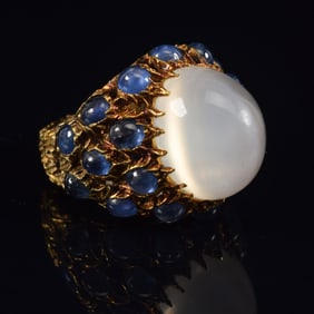 18K gold large sugarloaf moonstone and sapphire mounted ring. 20 cabochon sapphires. Flower