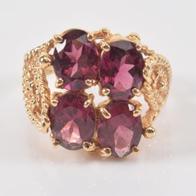 14K gold rubelite tourmaline mounted ring. 4 oval cut stones in a braided pierced setting. Ring size