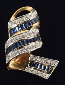 14K gold diamond and sapphire mounted pendant. Ribbon form with rows of rectangular cut sapphires
