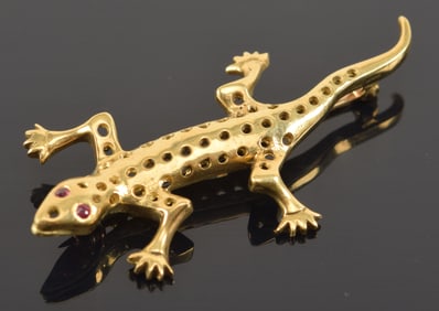 18K gold lizard pin with ruby mounted eyes. Other stone settings empty. Marked 18K on bottom of