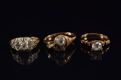 3 antique gold rings mounted with white sapphires. 1) Marked solitaire 10K. Ring size 6.5. 2) 14K