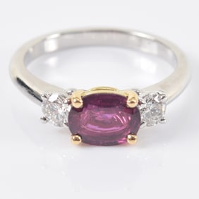 18K white gold ruby and diamond mounted ring. Natural oval cut ruby 1.12 cts. Flanked by two round